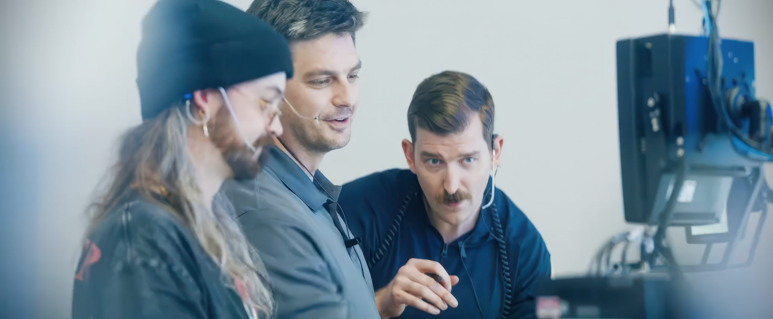 Three men work together on a computer performing engineering tasks at NASA